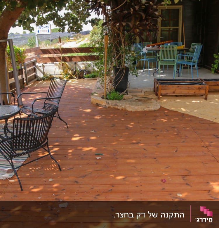 רצפת עץ עם שולחנות וכיסאות בגינה